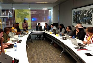 A facilitated training session in progress, with participants working at a shared conference table